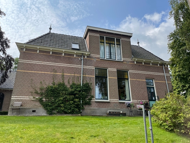       House with a large lawn and garden.
  