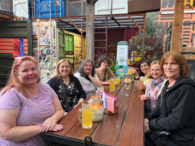 People sitting together enjoying drinks outside.