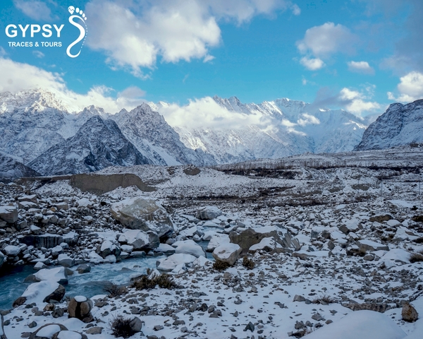       Snow-capped mountain range with clouds.
  