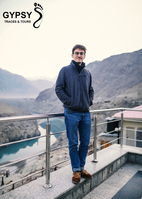       Person standing on a balcony overlooking a valley.
  