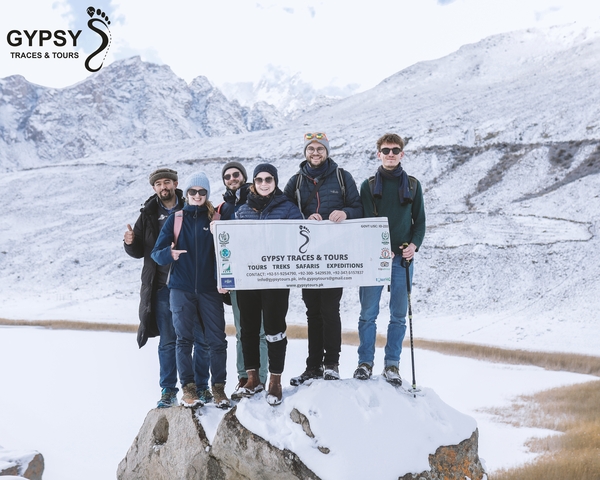       Group of people with a banner in snowy mountains.
  