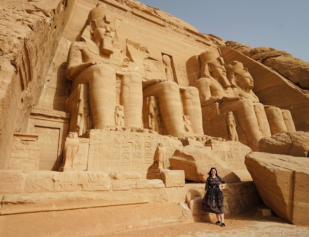 Person standing in front of the Abu Simbel temple statues.