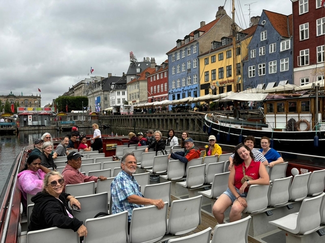       People on a boat tour in a colorful harbor.
  