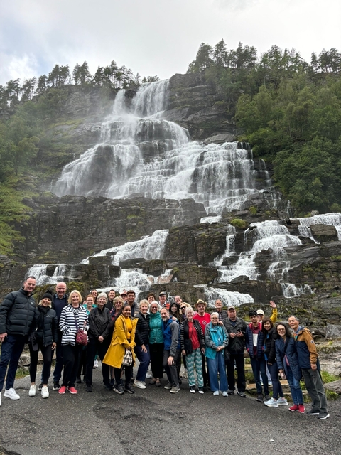       Group in front of a large waterfall.
  