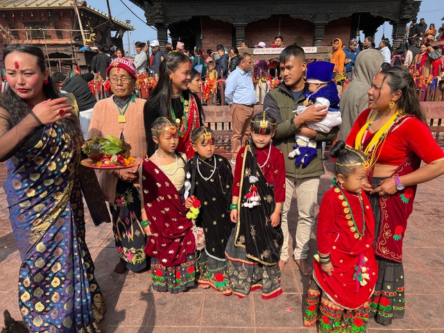       Family dressed in colorful traditional attire at a cultural event.
  