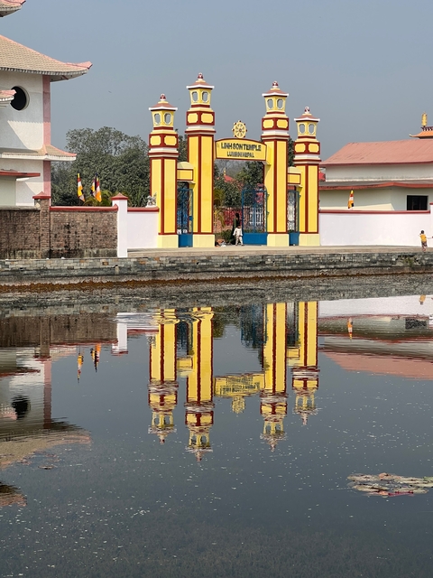       Colorful entrance gate with reflection in water.
  