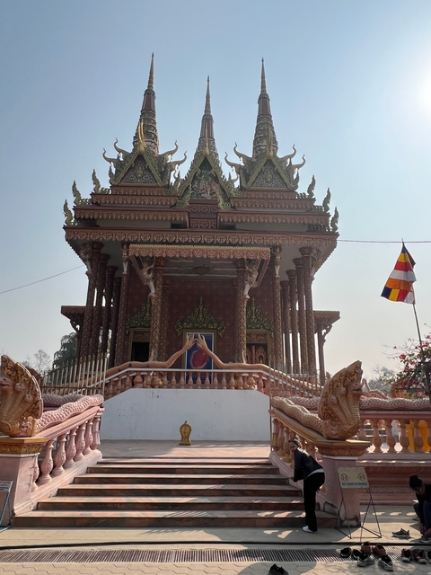       Golden stupa surrounded by trees and a clear sky.
  