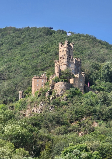 Castle perched on a lush hillside.