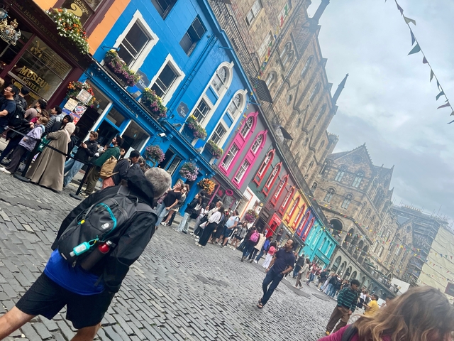 Colorful street with people and historic buildings.
