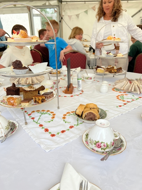       Table with a variety of pastries and sandwiches.
  