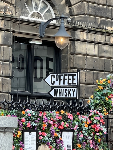       Sign for coffee and whisky on a building.
  