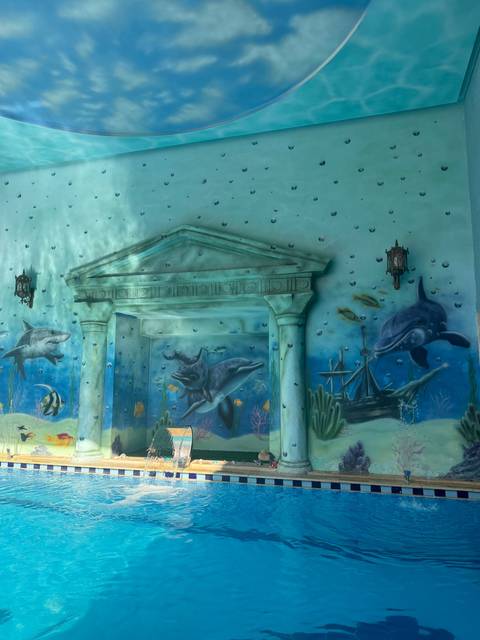 Underwater-themed mural with dolphins and sharks.