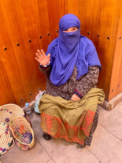       Woman in traditional attire greeting.
  