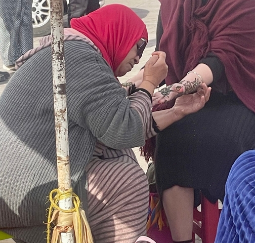       Henna application on a woman's hand.
  