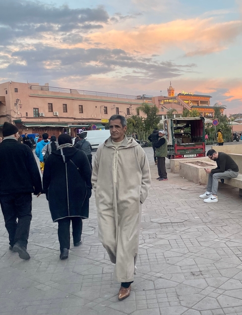      People walking in a public square.
  