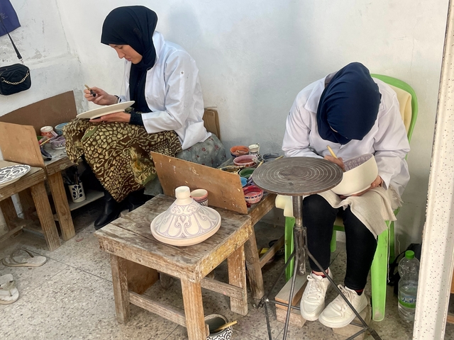       Women painting pottery.
  
