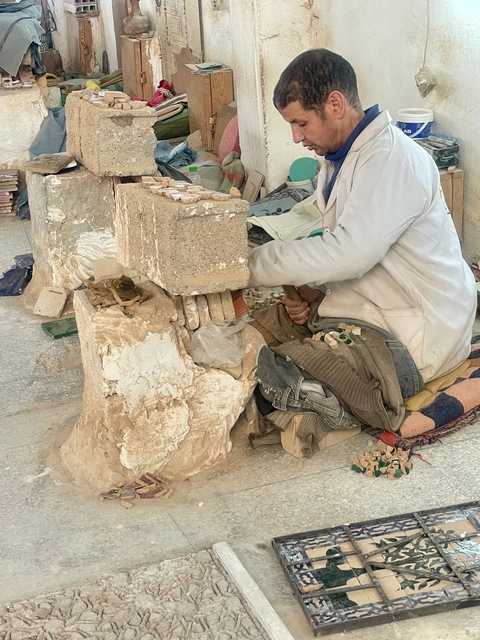       Person working with stones in a workshop.
  