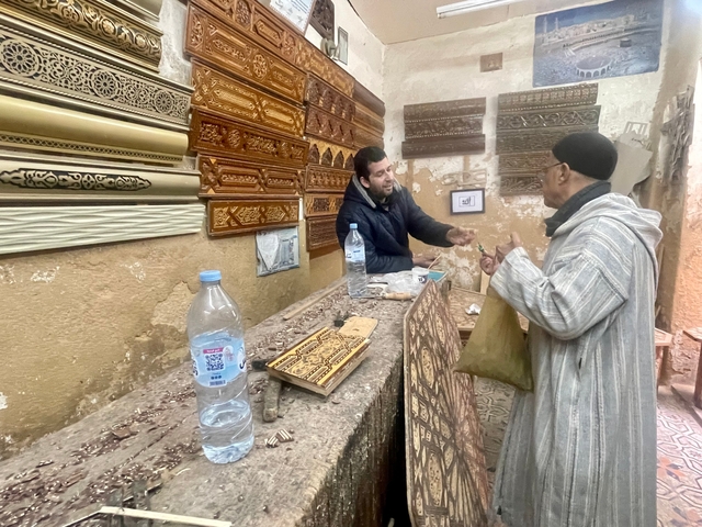       Shop with wooden carvings and client consulting.
  