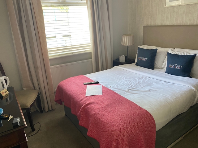 Interior of a hotel room with a neatly made bed.