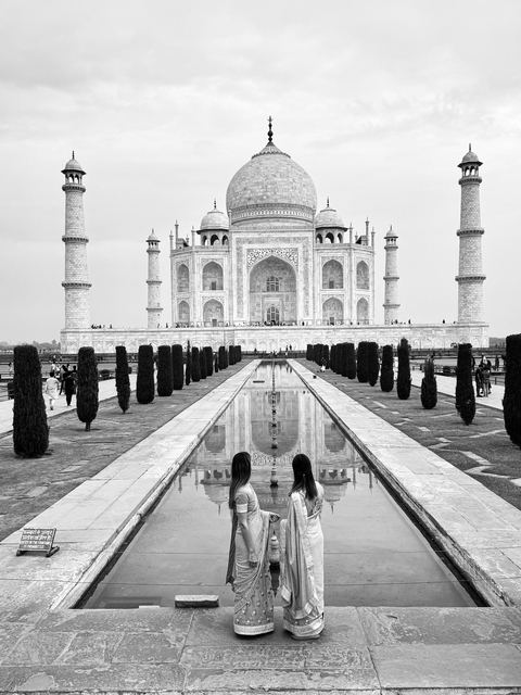       Taj Mahal with reflection and visitors in foreground.
  