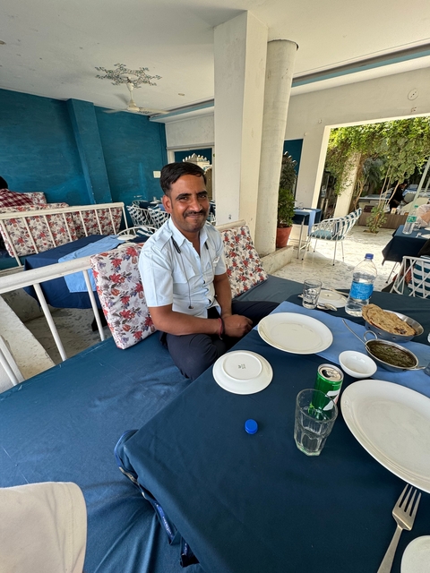       Man sitting at a restaurant table with dishes.
  