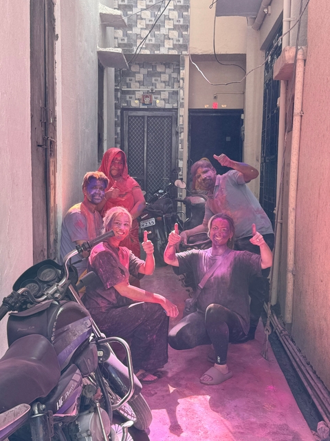       Group of people covered in colorful powder celebrating.
  