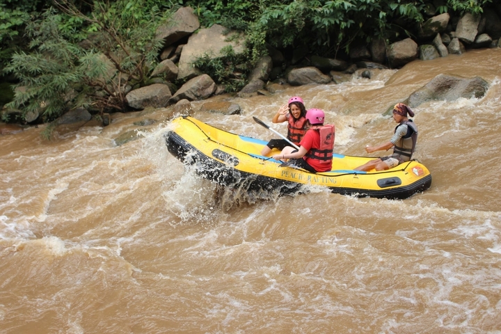       People white-water rafting on a river.
  