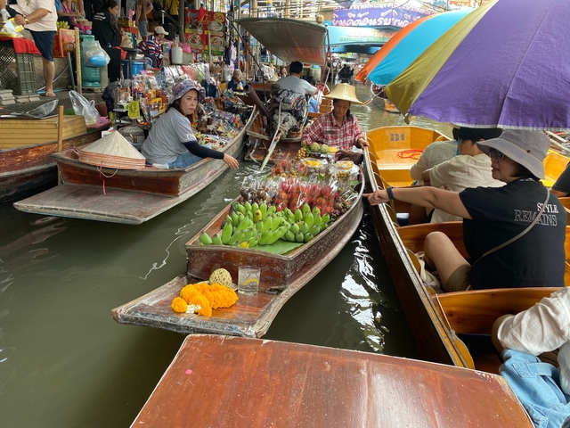 Floating market boats with people selling fruits.