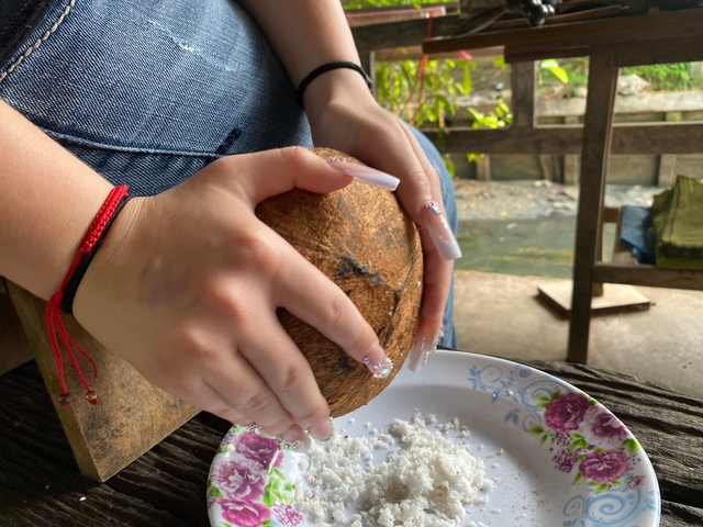       Person preparing a coconut for use.
  