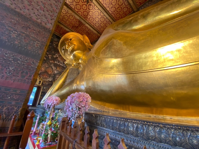       Golden reclining Buddha statue inside a temple.
  