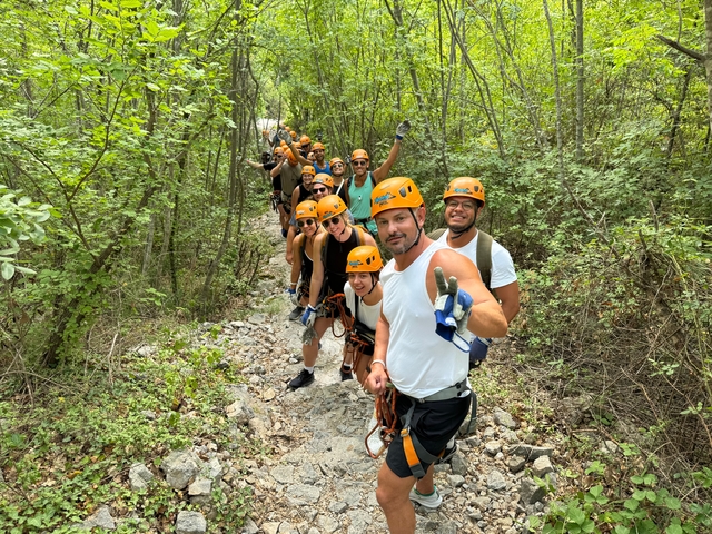       Group of people in helmets ready for zip lining.
  