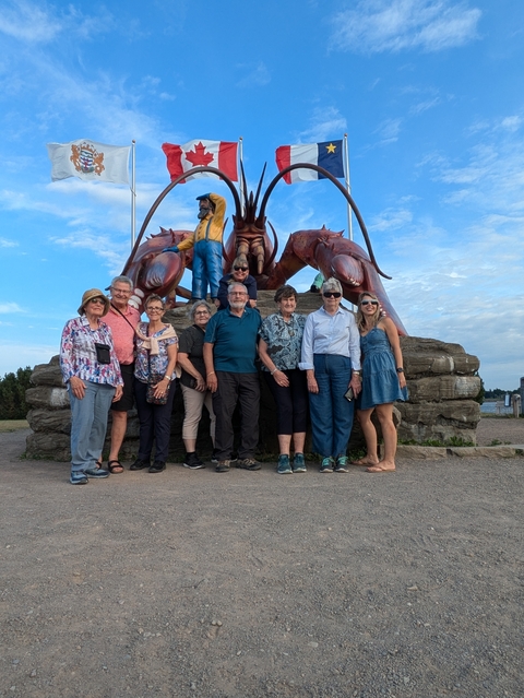 Group posing in front of a giant lobster statue.