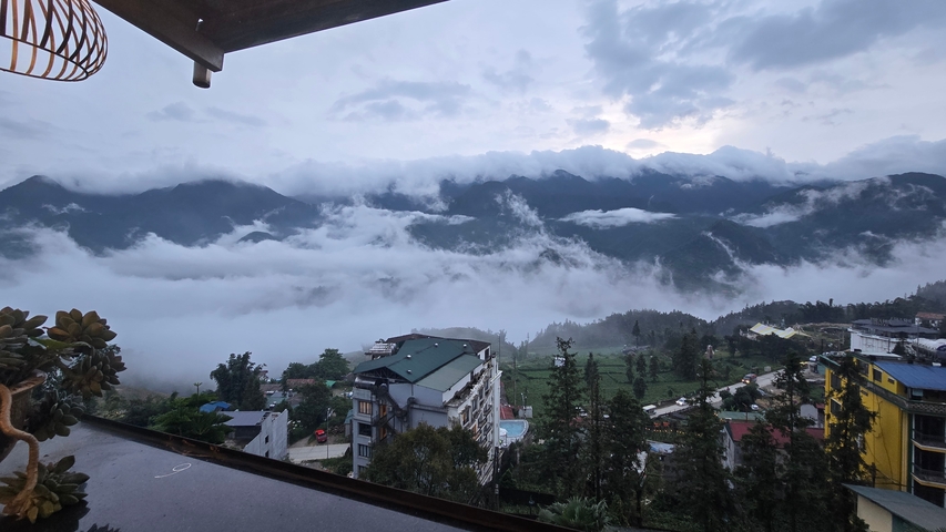       Misty mountains and clouds over a small town
  