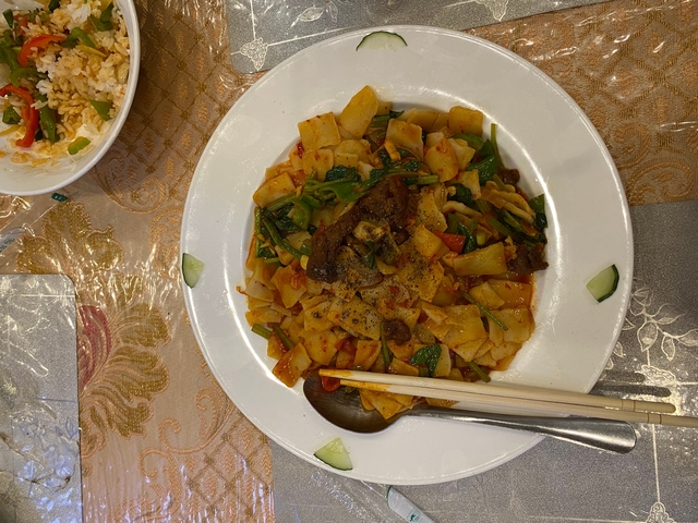 Plate of spicy noodles with vegetables and beef.