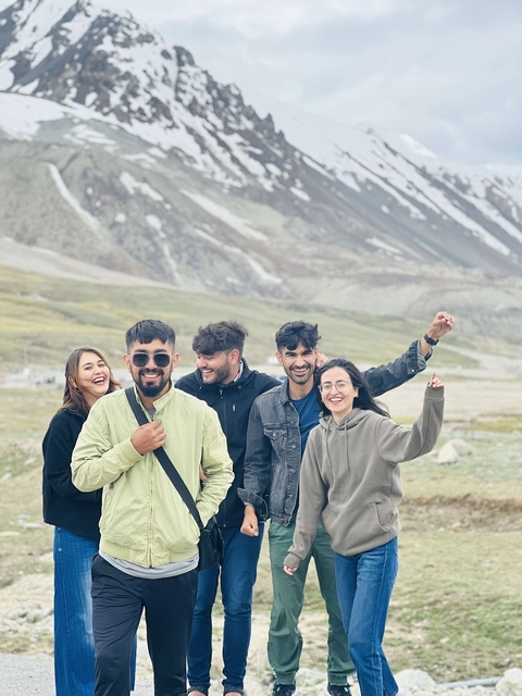Group of friends posing in a mountainous landscape.
