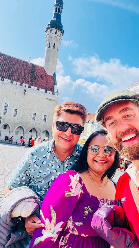 Three people taking a selfie in a public square with architecture.