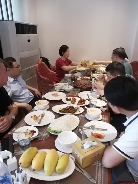Indoor dining scene with several people enjoying a meal.