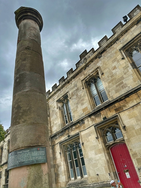       A section of a historical stone building with arched windows.
  
