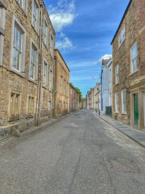 Quiet, historic street lined with stone buildings.