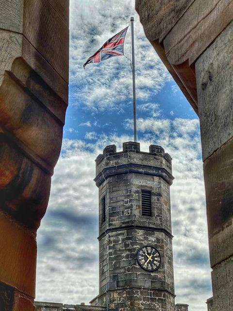 View of a small stone tower between large stone structures.