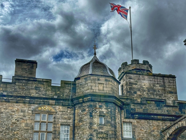 Stone building with a turret and a flag on top.