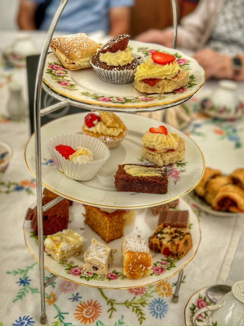       Afternoon tea with a tray of assorted pastries and sandwiches.
  