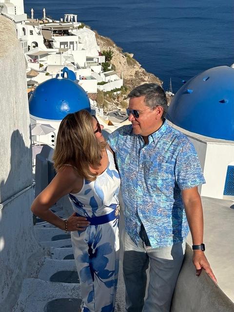       Couple standing in front of iconic blue-domed buildings
  