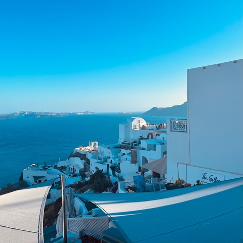       Charming whitewashed buildings on the steep cliffside with a sea view
  
