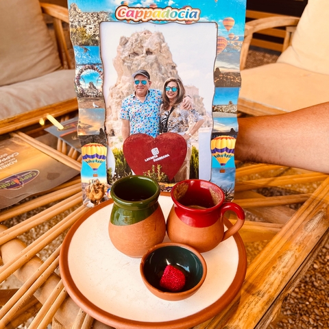       Photo of a couple in a frame with coffee mugs.
  