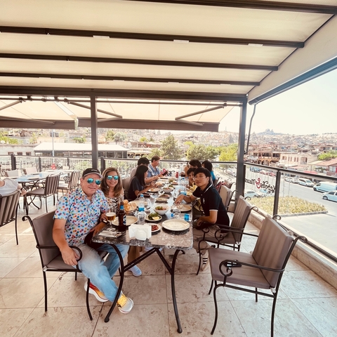       People dining on a patio with a cityscape view.
  