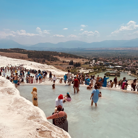       People enjoying the natural thermal pools with a scenic view
  