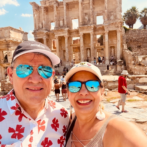       A couple posing in front of ancient ruins with detailed carving
  