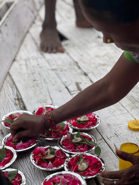       Arm reaching towards flower petals and bowls.
  