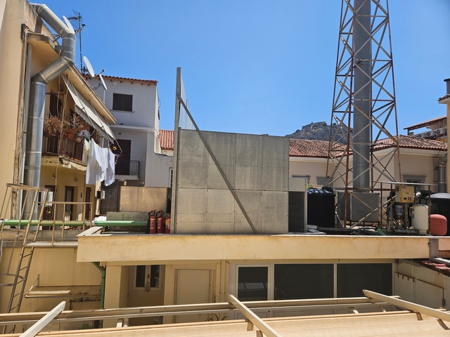 Urban rooftop with clothesline and metal structures.